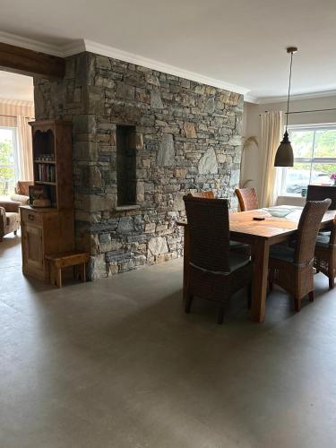 a dining room with a table and a stone wall at Shanakeever Farm - 3 Bedroom Apartment in Clifden