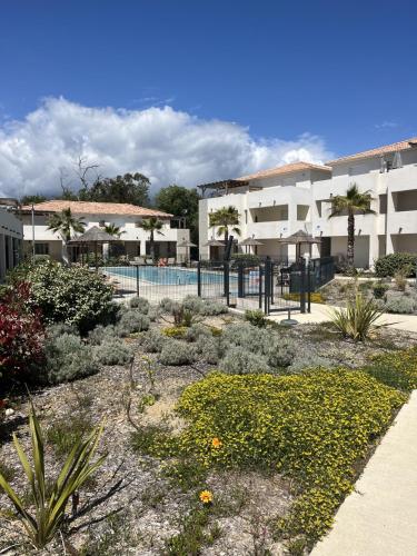 un jardin en face d'un bâtiment avec une piscine dans l'établissement Appartement à 2 Pas de la plage, à Linguizzetta