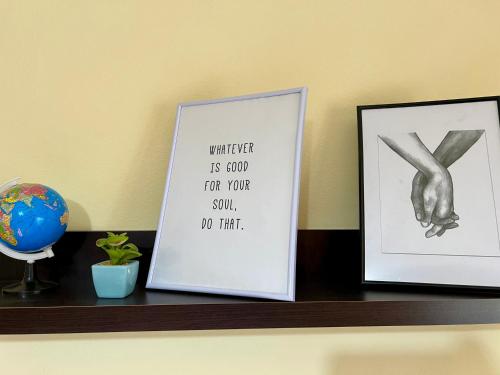 a shelf with two pictures and a sign on it at Guest House Dimos Kristi in Përmet