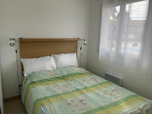 une chambre avec un lit avec une tête de lit en bois et une fenêtre dans l'établissement Appartement à 2 Pas de la plage, à Linguizzetta