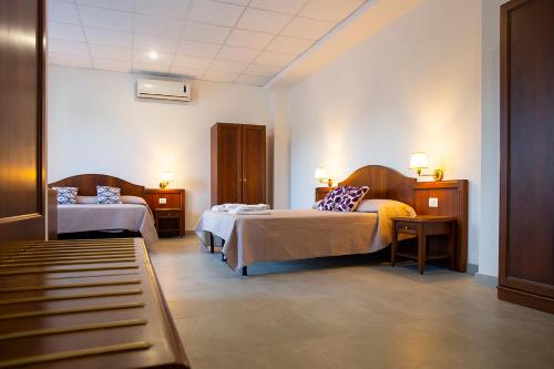 Habitación de hotel con 2 camas y sofá en Pennaluce, en Vasto