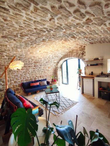 un salon avec un mur en pierre dans l'établissement L'Atelier des Huppes, à Joyeuse