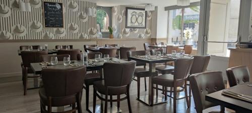 a dining room with tables and chairs and a chalkboard at Hôtel du Cheval Blanc - Paris Marne La Vallée in Jossigny