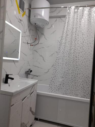 a bathroom with a white shower curtain and a sink at Apartment 2хкомнатрая квартира in Osh