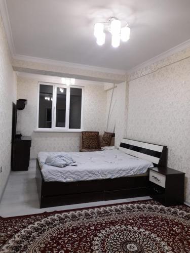 a bedroom with a large bed and a rug at Apartment 2хкомнатрая квартира in Osh