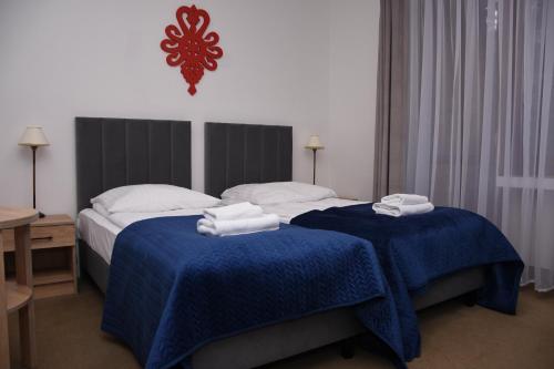 Cette chambre d'hôtel comprend 2 lits avec des draps bleus. dans l'établissement Hotel Boruta, à Zakopane