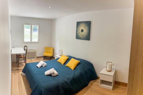 - une chambre avec un lit bleu et des oreillers jaunes dans l'établissement Belle villa avec jardin piscine et salle de sport, à Montauroux