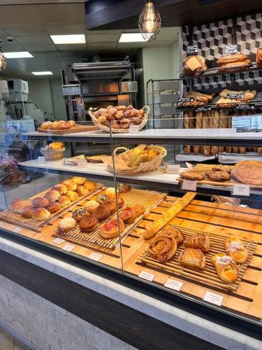 une boulangerie remplie de nombreux types de pâtisseries différentes dans l'établissement Appartement moderne Paris Montmartre 2 à 4p, à Paris