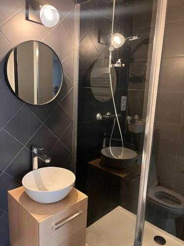 une salle de bain avec un lavabo et une douche avec un miroir dans l'établissement Appartement moderne Paris Montmartre 2 à 4p, à Paris