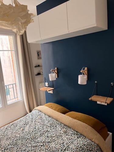 une chambre bleue avec un lit et une fenêtre dans l'établissement Appartement moderne Paris Montmartre 2 à 4p, à Paris