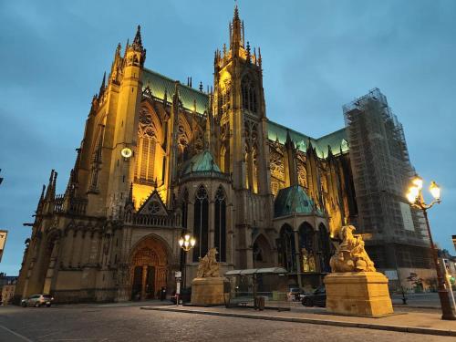 a large cathedral with a clock tower in front of it at The Great Wave, appartement calme avec terrasse et parking gratuit in Ban-Saint-Martin