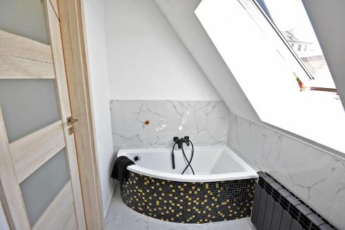 a bathroom with a bath tub in the attic at Apartamenty Basztowa in Świdnica