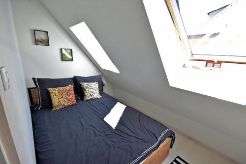 a bed in a small room with a window at Apartamenty Basztowa in Świdnica