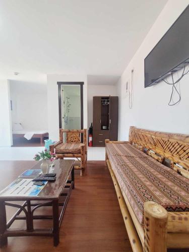 a living room with two beds and a table at Gaja Go Dive & Inn in Moalboal