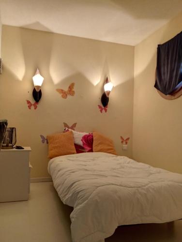 a bedroom with a bed with butterflies on the wall at Appartement Chasseneuil Futuroscope in Chasseneuil-du-Poitou