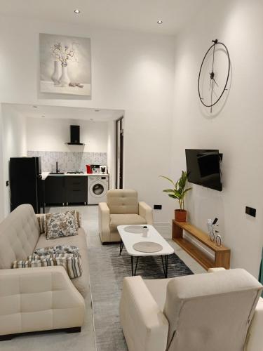 a living room with white furniture and a tv at Harmony Hideaway in Gabala