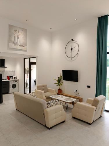 a living room with couches and a clock on the wall at Harmony Hideaway in Gabala
