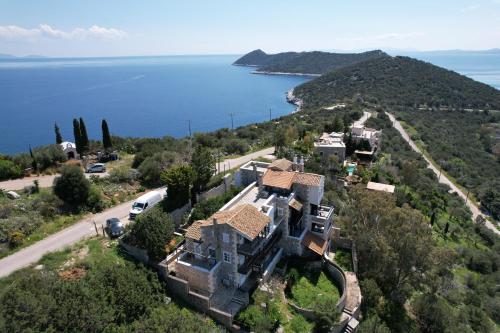 an aerial view of a house on a hill next to the water at TΟRRE DI PIETRA-LUXURY RESIDENCE-ΑMAZING SEA VIEW in Marathón