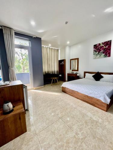 ein Schlafzimmer mit einem Bett und einem großen Fenster in der Unterkunft Khách Sạn Trung Anh 78 HAI BÀ TRƯNG BMT in Buon Ma Thuot