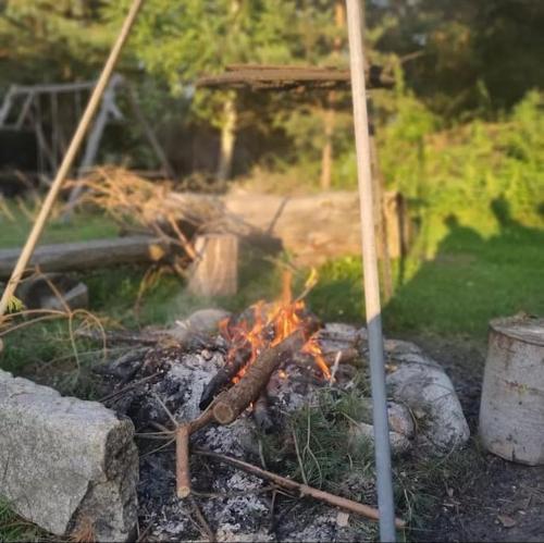 a fire in a yard next to some rocks at W Otulinie Czerwonej Góry in Chęciny