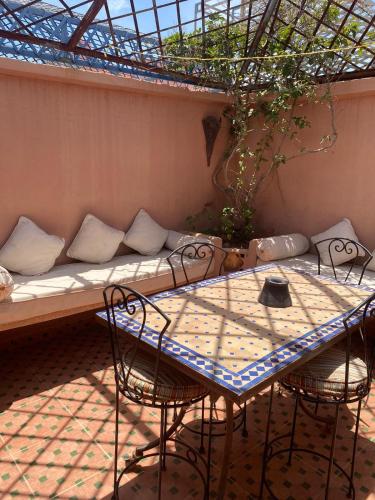 a table and chairs with a couch on a patio at Riad Nour Resorts-Riad Nour Travel in Marrakech