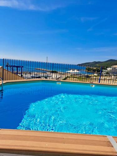 une grande piscine bleue avec vue sur l'océan dans l'établissement Appartement Vue Mer, à Sari-Solenzara