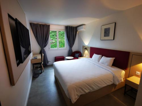 Anaïs Hôtel Bourges Nord Saint-Doulchard في بورج: غرفه فندقيه بسرير ونافذه
