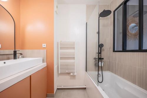 une salle de bain avec une baignoire, un lavabo et une douche dans l'établissement Charming modern and bright apartment 4P, aux Lilas