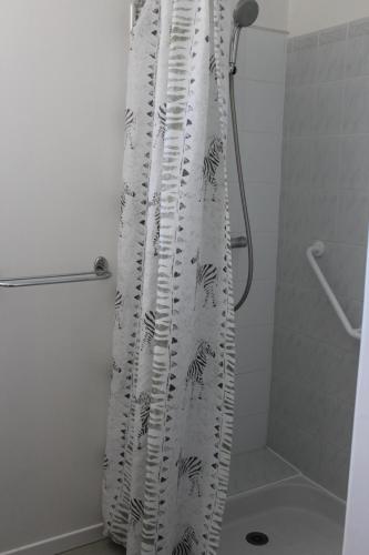 La salle de bains est pourvue d'un rideau de douche. dans l'établissement Meublé14 avec terrasse, à Gréoux-les-Bains