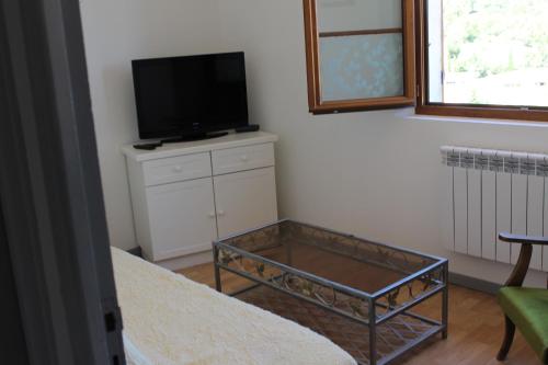 une pièce avec une télévision et une table avec une table basse sidx sidx sidx sidx dans l'établissement Meublé14 avec terrasse, à Gréoux-les-Bains