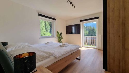 een slaapkamer met een bed en 2 ramen bij Ferienwohnungen Rabensteiner in Bad Kleinkirchheim