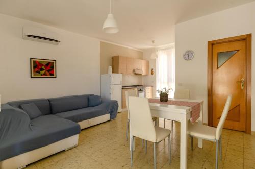 un soggiorno con un divano, un tavolo e delle sedie di Casa I Gabbiani a Mattinata