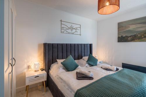 a bedroom with a large bed with blue pillows at Akvarell Apartmanház in Zebegény