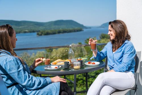 two women sitting at a table eating food at Akvarell Apartmanház in Zebegény