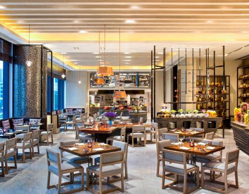 a restaurant with tables and chairs and a kitchen at W Guangzhou in Guangzhou
