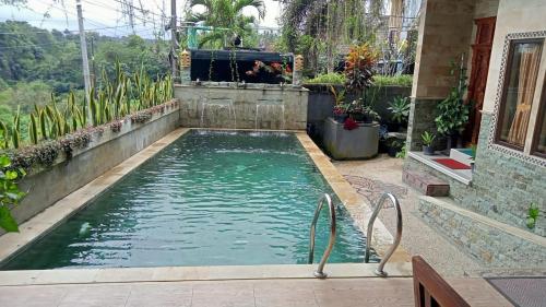 a swimming pool in a backyard with plants at Villa Army Tabanan in Tabanan