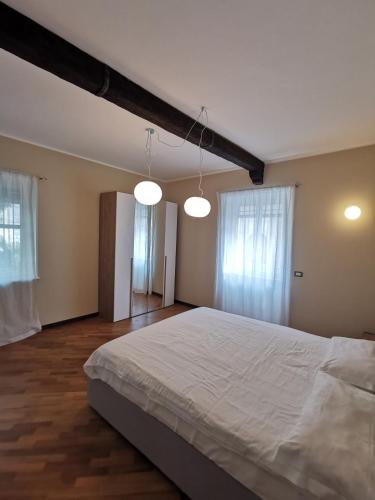 una camera da letto con un grande letto bianco con due luci di Flora Inn Scotti's House - Due passi in centro a Bergamo