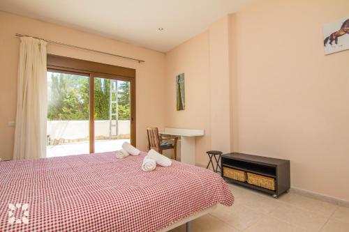 a bedroom with a bed and a tv and a window at Villa Medina 20 by Abahana Villas in Moraira