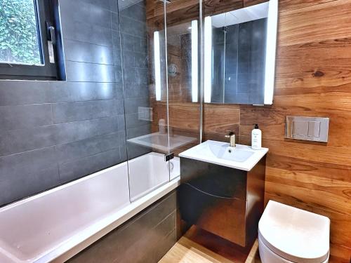 a bathroom with a sink and a toilet and a tub at Chy Mena. South facing lodge with hot tub & views. in St. Agnes 