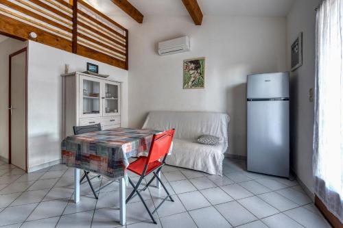 une cuisine avec une table et un réfrigérateur dans l'établissement Maisonnette, au Barcarès