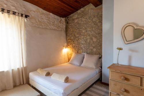 ein Schlafzimmer mit einem Bett und einer Steinmauer in der Unterkunft Montclar in Montclar