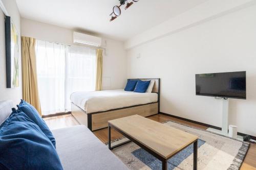 a living room with two beds and a tv at Anri Kitazume in Osaka