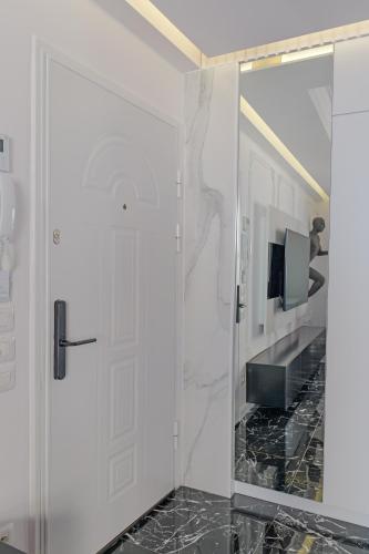 a glass shower door in a bathroom with a television at New Beach Suite in Sarandë