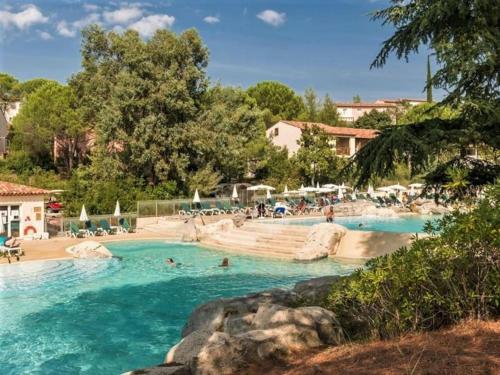 - une piscine dans un complexe avec des personnes dans l'eau dans l'établissement Maison duplex - Domaine P&V Le Rouret - Proche Vallon Pont d'Arc, à Grospierres