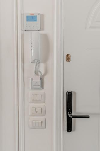 a white refrigerator with a phone on the door at New Beach Suite in Sarandë