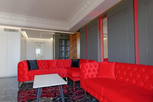 a living room with red couches and a table at New Beach Suite in Sarandë