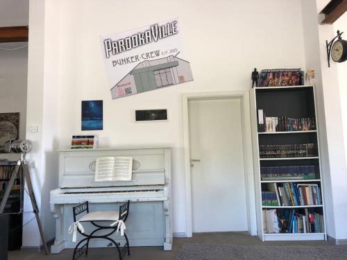 a room with a white piano and a book shelf at Bunker 35 in Kevelaer