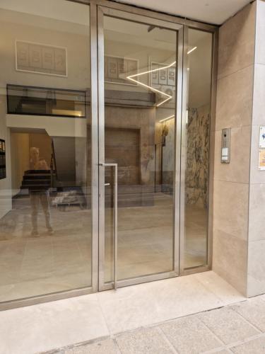 a glass door of a building with a person in the reflection at Balcón del Malecón in Murcia