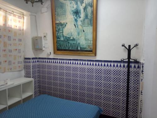 baño con una pared de azulejos azules y blancos en Pensión Santa María la Blanca, en Sevilla