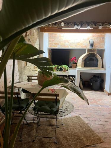 a living room with a table and a pizza oven at rural-home callemayor in Altura